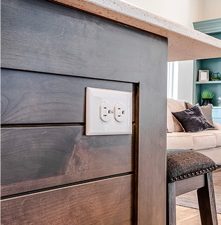 A close-up of a modern electrical outlet, representing PowerMeans' expert electrical design services.